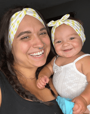 Mom and baby girl are wearing matching mommy and me head wraps from By Bella Boutique. Mom and baby girl are wearing matching mommy and me head wraps from By Bella Boutique.