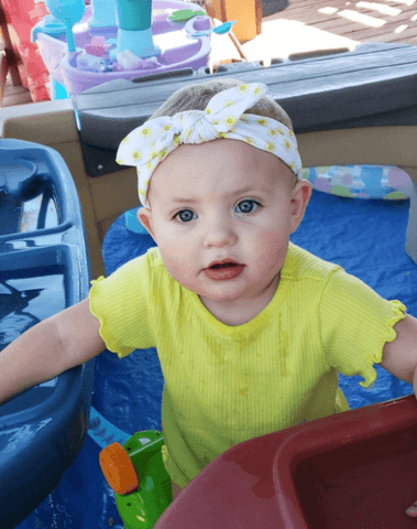Baby girl is wearing a comfortable baby head wrap from By Bella Boutique. Baby girl is wearing a comfortable baby head wrap from By Bella Boutique.