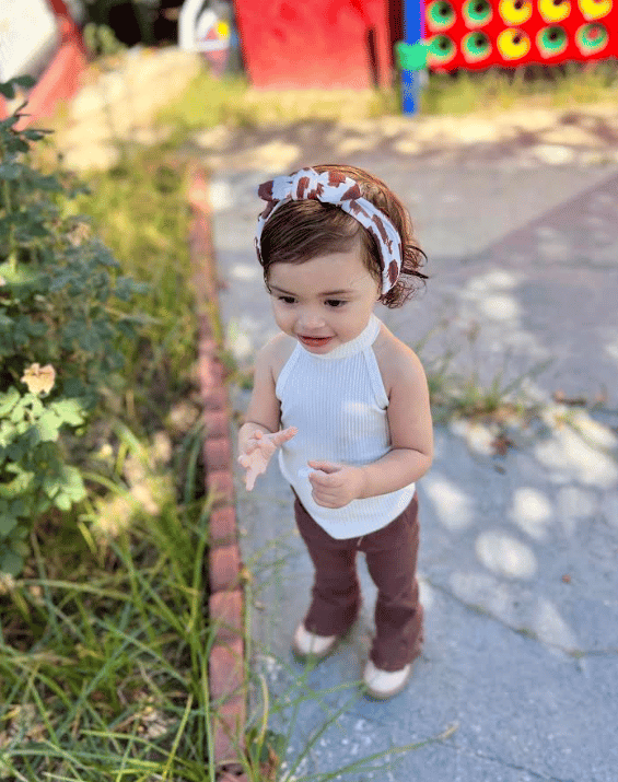 Little girl is wearing a baby headband for little girls from By Bella Boutique.