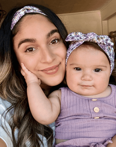 Mom and daughter are wearing matching mommy and me headbands from By Bella Boutique.