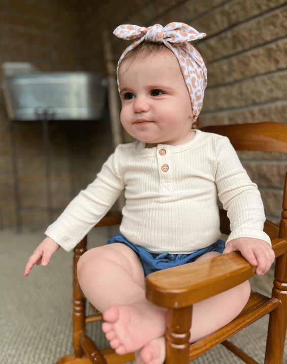 Baby girl is wearing a soft baby headband for little girls from By Bella Boutique.