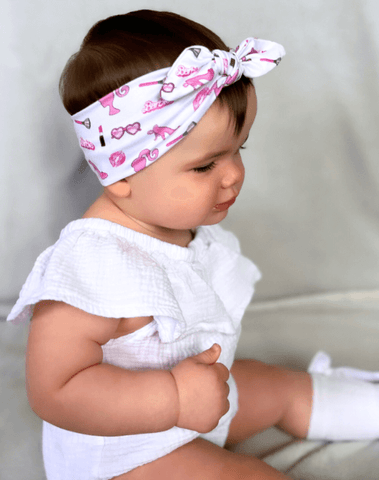 Baby girl is wearing a soft baby head wrap for little girls from By Bella Boutique.