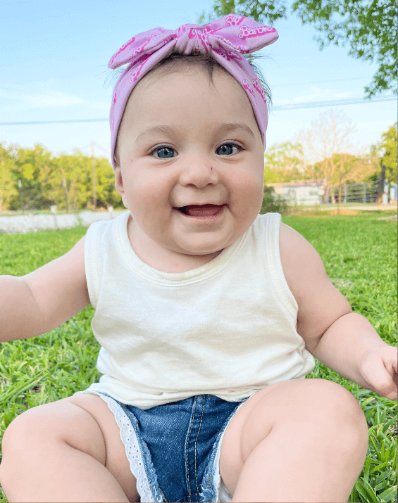 Little girl is wearing a comfortable baby headband for little girls from By Bella Boutique.