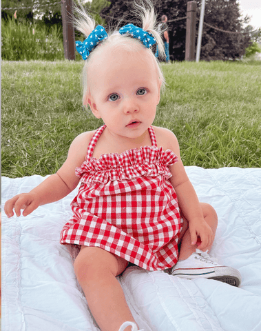 Toddler girl is wearing a set of handmade clip bows from By Bella Boutique.