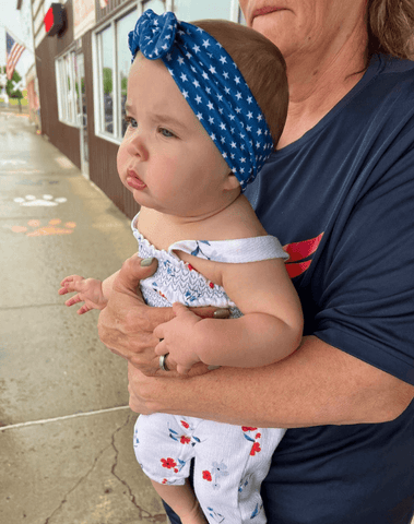 Little girl is wearing a baby girl headband for little girls from By Bella Boutique.