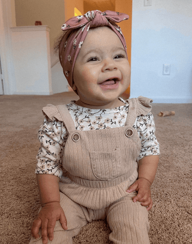 Baby girl is wearing a soft baby girl headwrap for little girls from By Bella Boutique.