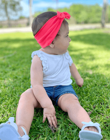 Little girl is wearing a comfortable baby head wrap for little girls from By Bella Boutique.