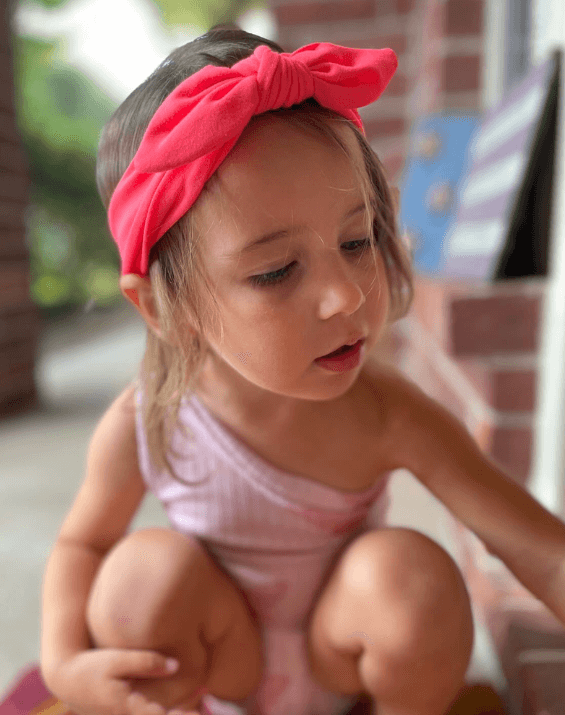 Little girl is wearing a baby head wrap for little girls from By Bella Boutique.
