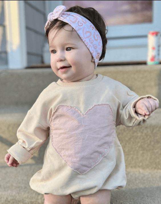Toddler girl is wearing a comfortable baby head wrap for little girls from By Bella Boutique.