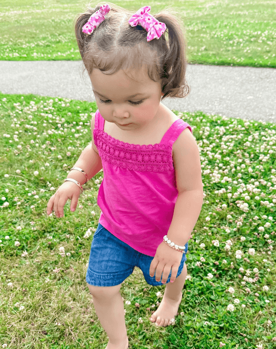 Toddler girl is wearing a pair of handmade bow clips from By Bella Boutique.