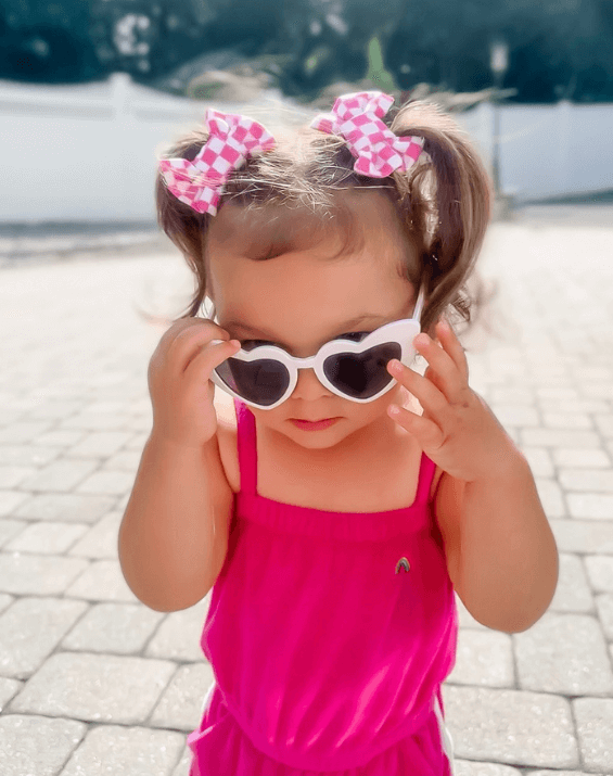 Little girl is wearing a pair of handmade clip bows for toddler girls from By Bella Boutique.