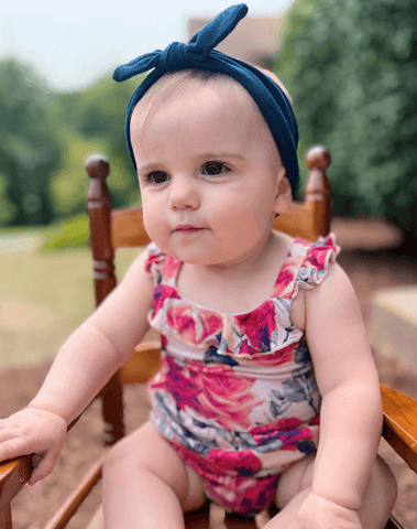 Little girl is wearing a baby headband for little girls from By Bella Boutique.
