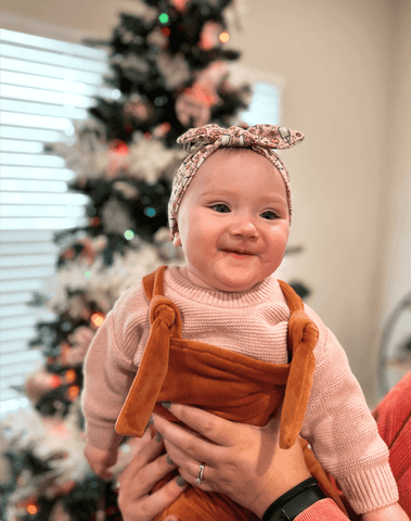 Little girl is wearing a soft baby head wrap for little girls from By Bella Boutique. 