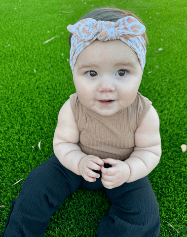 Little girl is wearing a soft baby headband for little girls from By Bella Boutique.