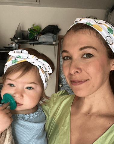 Mom and daughter are wearing mommy and me head wraps from By Bella Boutique.