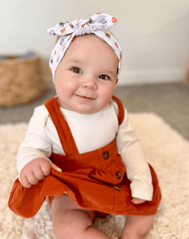 Baby girl is wearing a comfortable baby headband for little girls from By Bella Boutique.