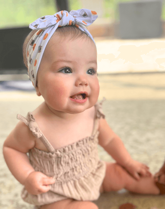 Baby girl is wearing a baby head wrap for little girls from By Bella Boutique.