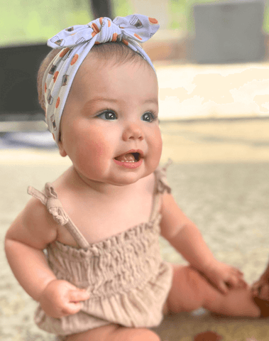 Baby girl is wearing a baby head wrap for little girls from By Bella Boutique.