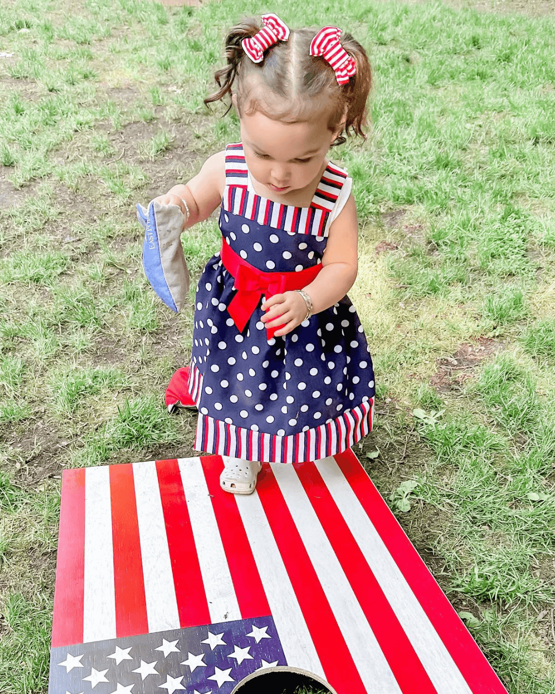 Little girl is wearing a set of handmade clips bows for toddler girls from By Bella Boutique.
