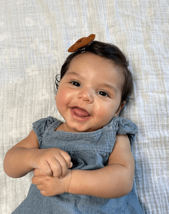 Little girl is wearing a set of handmade bow clips for toddler girls from By Bella Boutique.