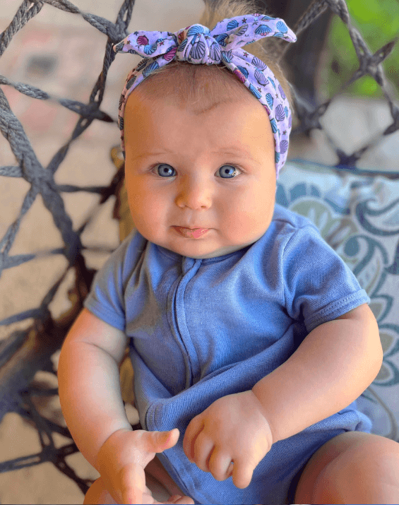 Baby girl is wearing a soft baby head wrap for little girls from By Bella Boutique.