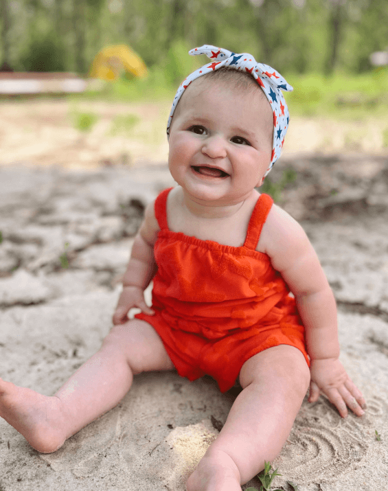 Little girl is wearing a knotted head wrap for little girls from By Bella Boutique.
