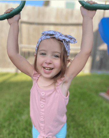 Little girl is wearing a baby head wrap for little girls from By Bella Boutique.