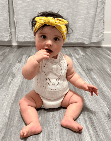 Baby girl is wearing a comfortable baby headbad for little girls from By Bella Boutique.