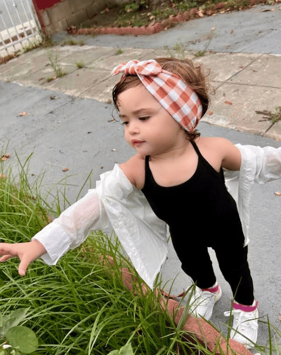 Little girl is wearing a comfortable baby headband for little girls from By Bella Boutique.