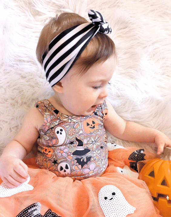 Little girl is wearing a comfortable baby headband for little girls from By Bella Boutique.