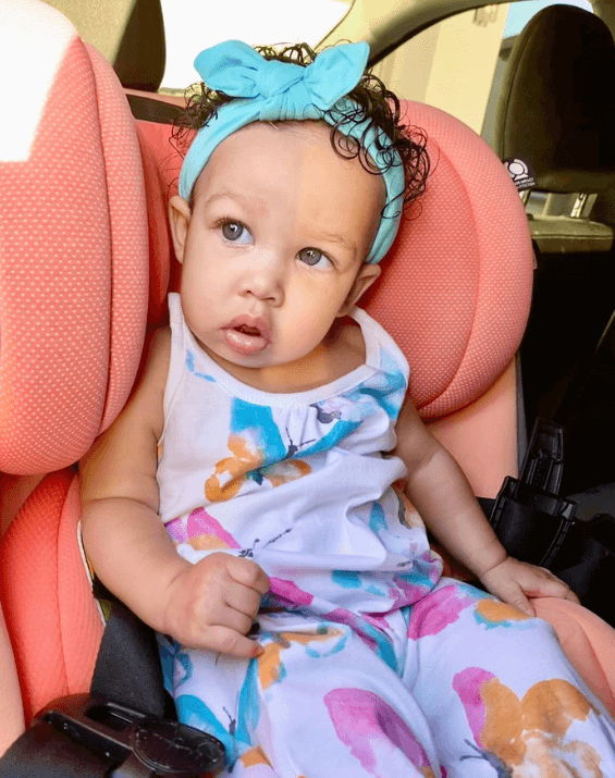 Baby girl is wearing a comfortable baby head wrap from By Bella Boutique.