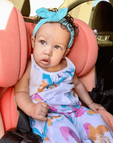 Baby girl is wearing a comfortable baby head wrap from By Bella Boutique.