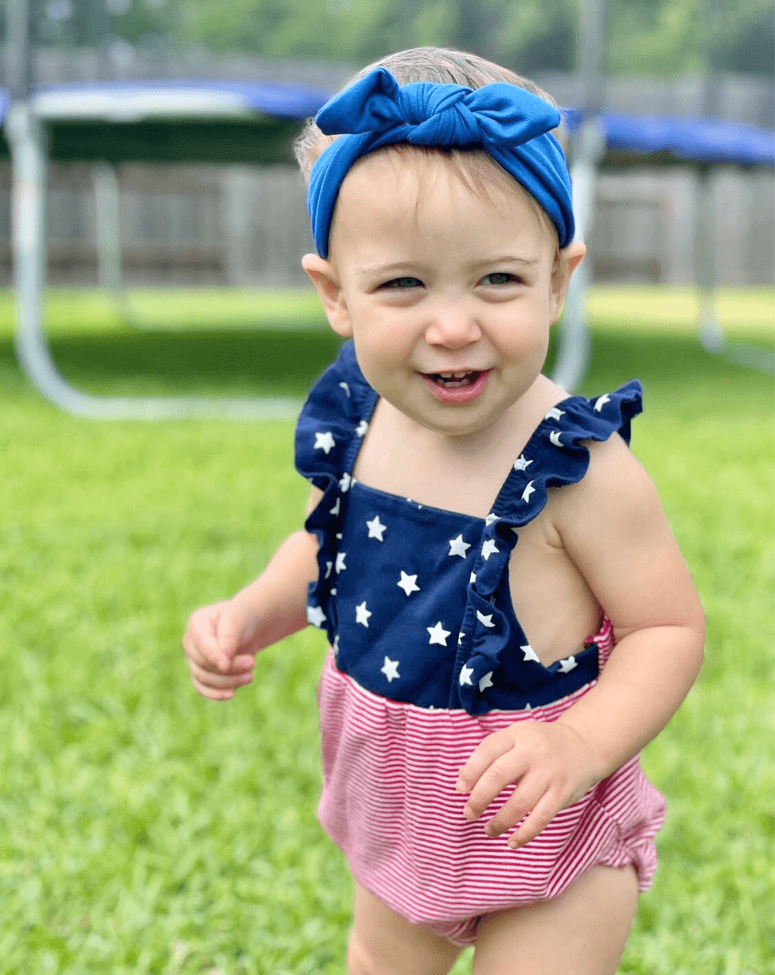 Little girl is wearing a blue knot headband for little girls from By Bella Boutique.