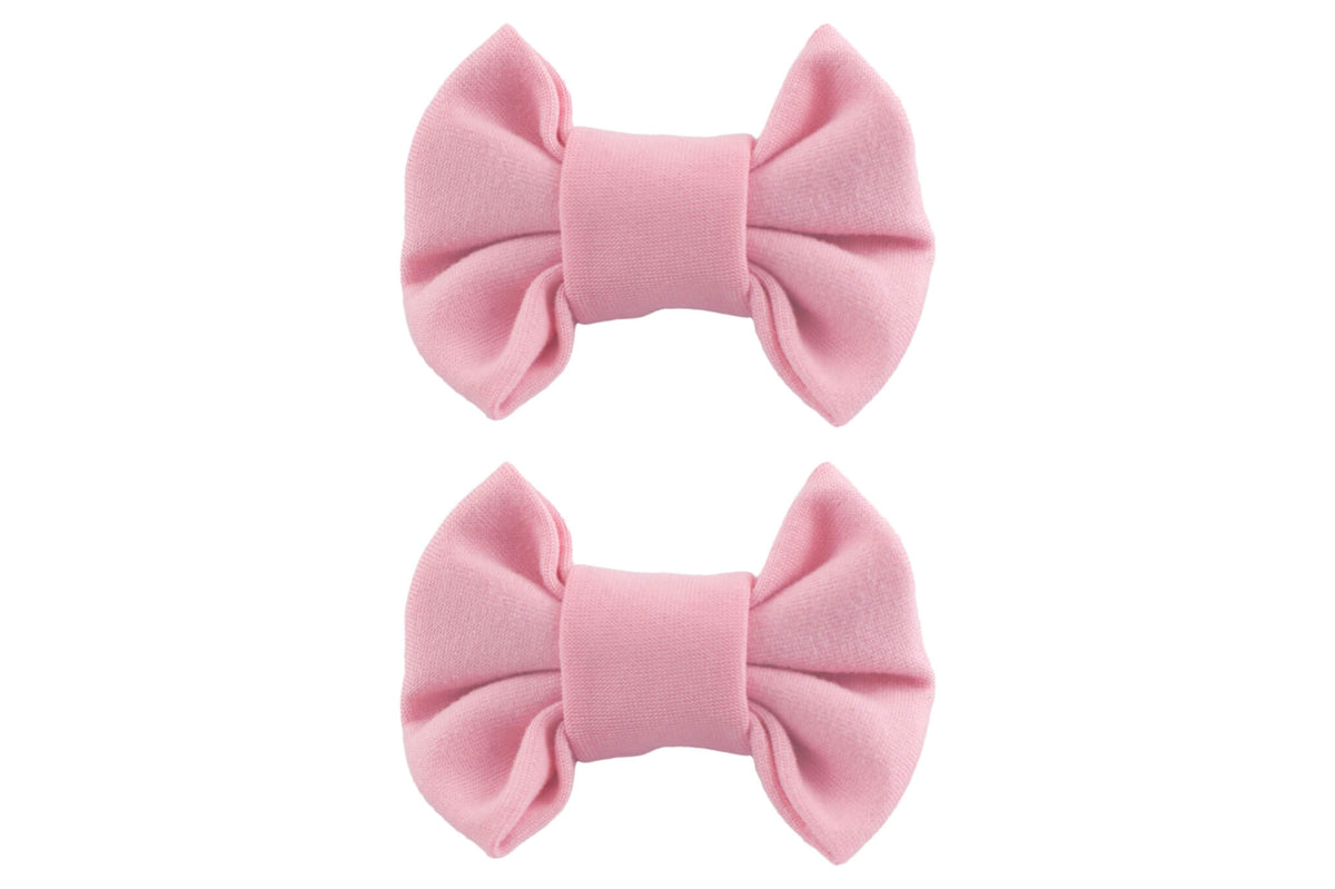 A pair of handmade pink bow clips for toddler girls from By Bella Boutique.