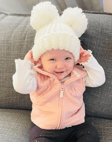 Baby girl is wearing a newborn beanie for little girls from By Bella Boutique.