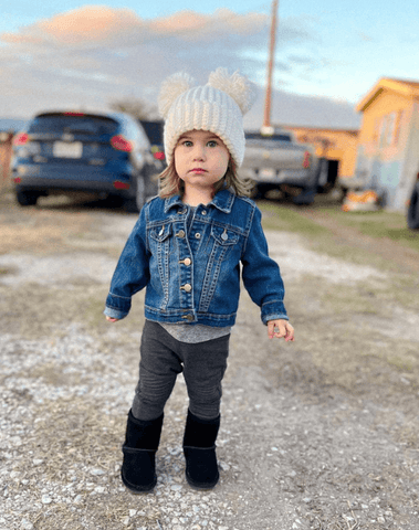 Toddler girl is wearing a handmade crochet beanie from By Bella Boutique.