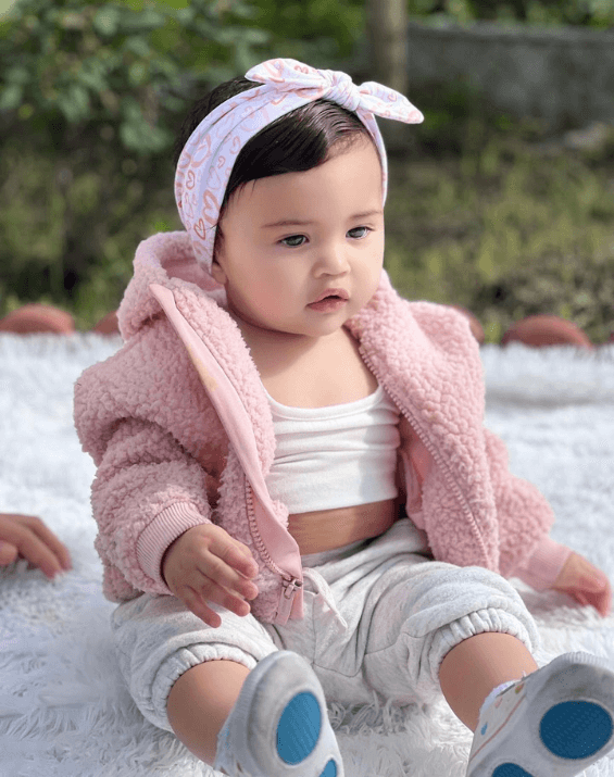 Baby girl is wearing a comfortable baby bow for little girls from By Bella Boutique.