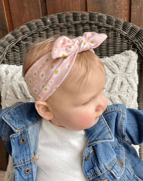 Baby girl is wearing a comfortable baby head wrap for little girls from By Bella Boutique.