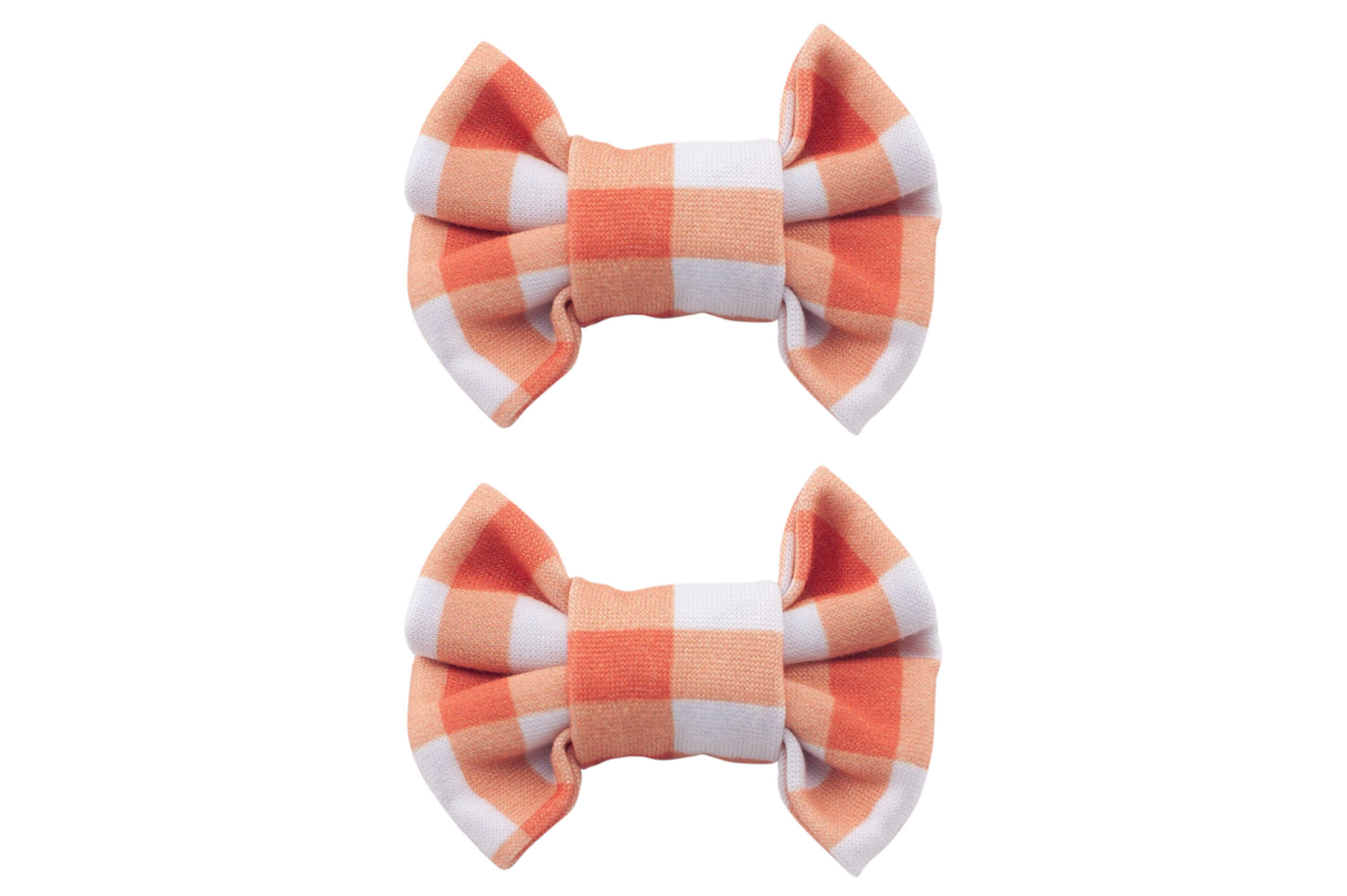 A set of two handmade clip bows featuring an orange gingham pattern for toddler girls from By Bella Boutique.