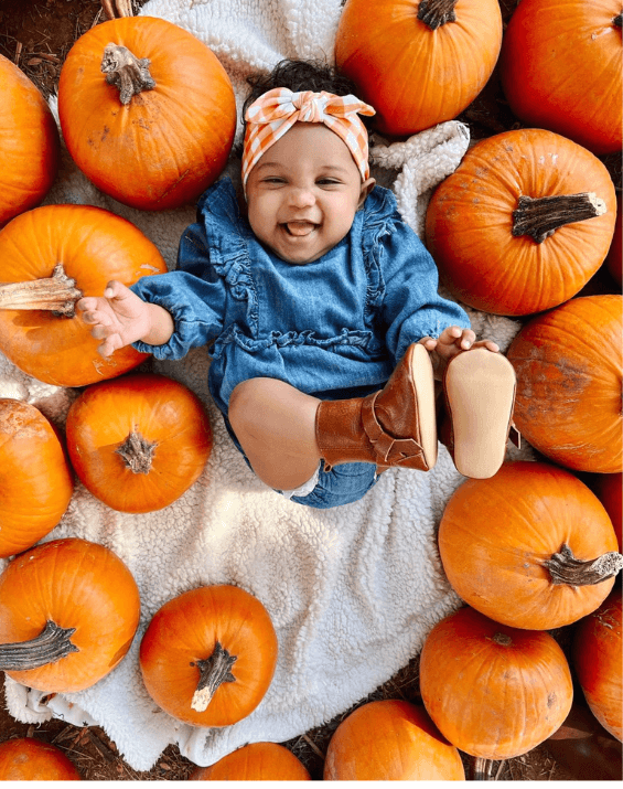 Little girl is wearing a comfortable baby head wrap featuring a gingham print for little girls from By Bella Boutique.