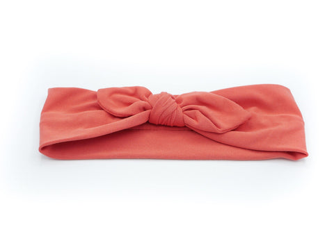 An orange knotted head wrap from By Bella Boutique.