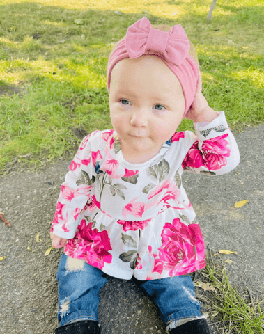 Little girl is wearing a comfortable baby girl head wrap for little girls from By Bella Boutique.