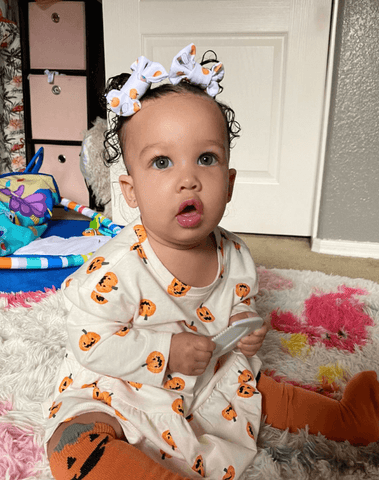 Little girl is wearing a handmade clip bows for toddler girls from By Bella Boutique.