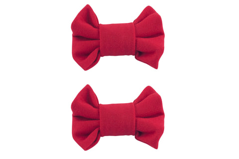 A set of two handmade red bow clips for toddler girls from By Bella Boutique.