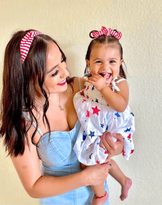 Mom and daughter are wearing matching mommy and me headbands from By Bella Boutique.