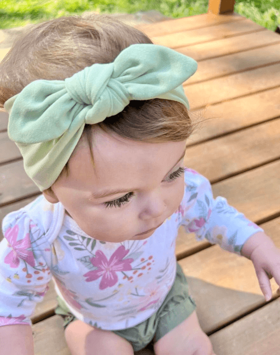 Baby girl is wearing a baby headband for  little girls from By Bella Boutique.