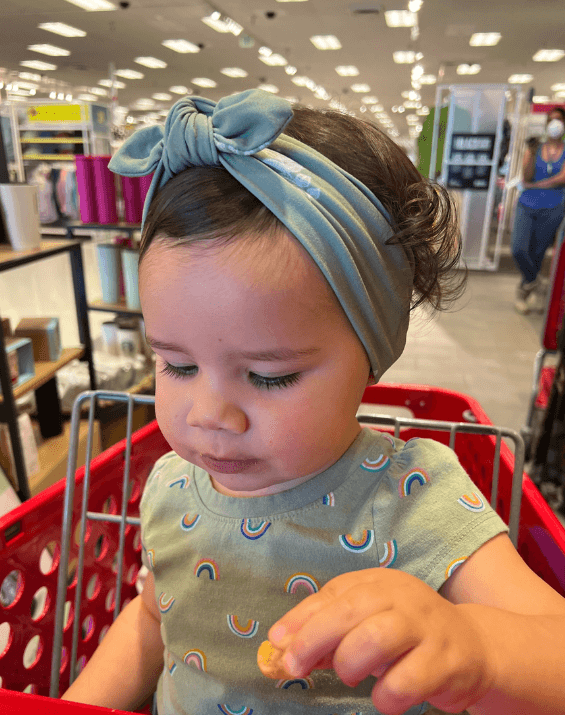 Baby girl is wearing a knotted head wrap for little girls from By Bella Boutique.