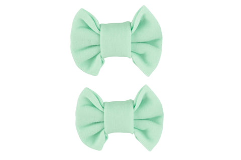 A pair of seafoam green bow clips from By Bella Boutique.