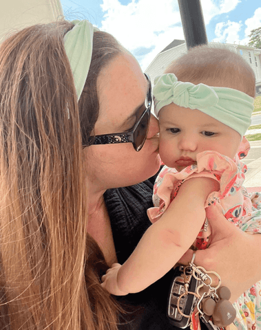 Mom and daughter are wearing matching mommy and me headbands from By Bella Boutique.