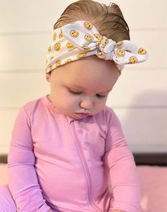 Baby girl is wearing a comfortable baby bow for little girls from By Bella Boutique.